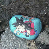 Un petit guerrier s’est glissé dans une cachette sombre, entre les rochers. Cherche près d’une fissure, là où la pierre forme une petite grotte… son sourire devrait te guider ! 🐉
