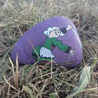 Une petite jardinière en violet s’est cachée dans l’herbe… ouvrez l’œil pour retrouver ce galet !